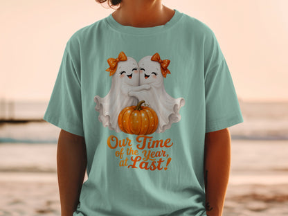 Two watercolor ghosts hug a pumpkin with text "Our Time of the Year, at Last!"