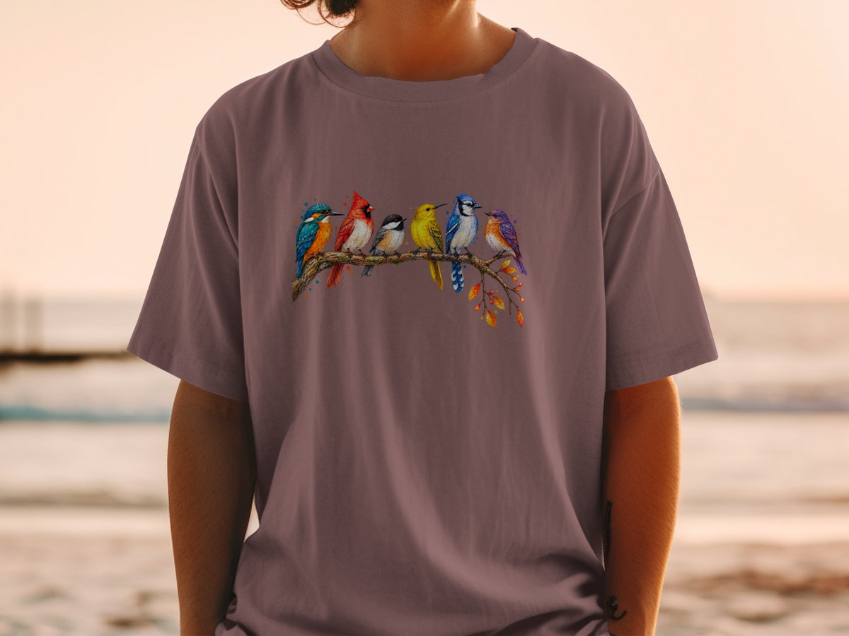 T-shirt featuring a watercolor illustration of six colorful birds perched on a branch.