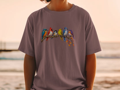 T-shirt featuring a watercolor illustration of six colorful birds perched on a branch.