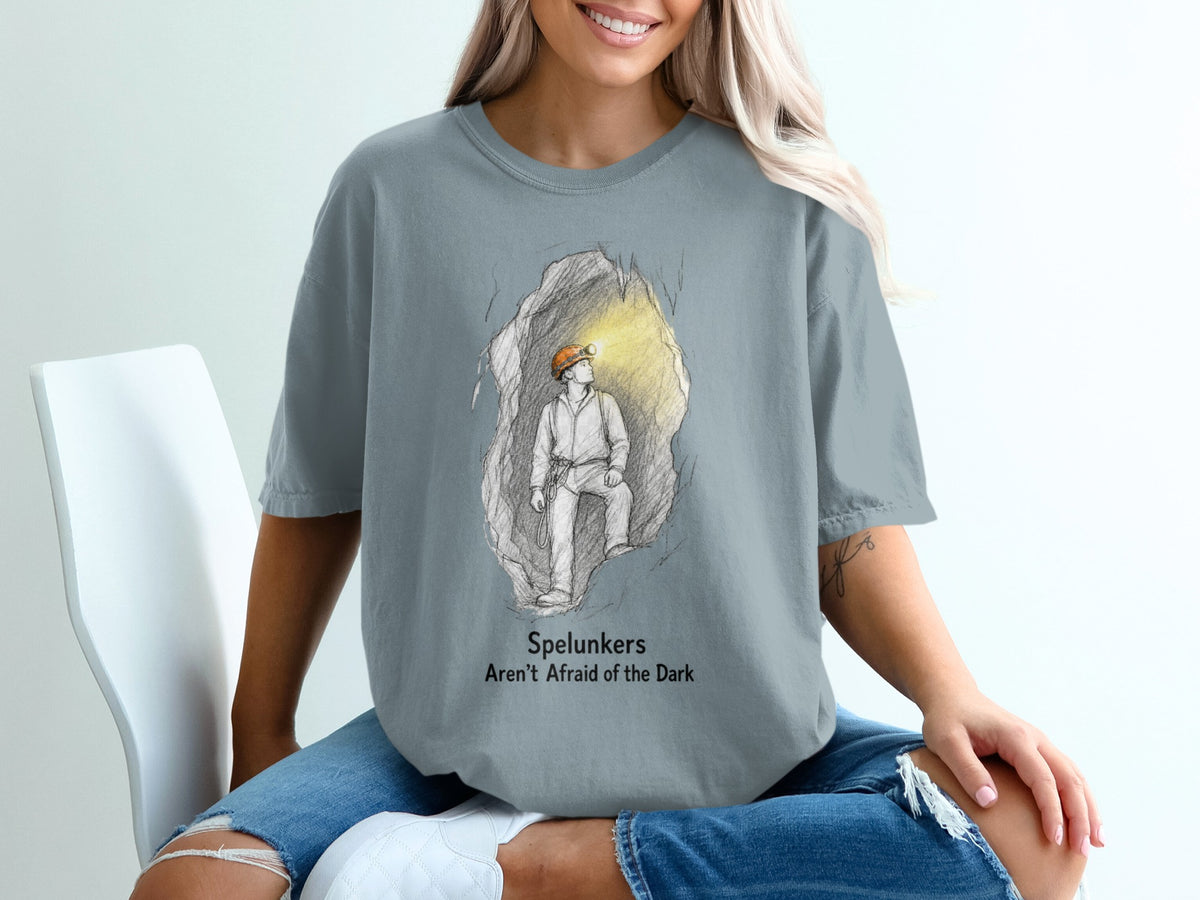 T-shirt graphic of spelunker in cave with text "Spelunkers Aren't Afraid of the Dark".