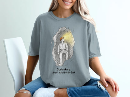 T-shirt graphic of spelunker in cave with text "Spelunkers Aren't Afraid of the Dark".