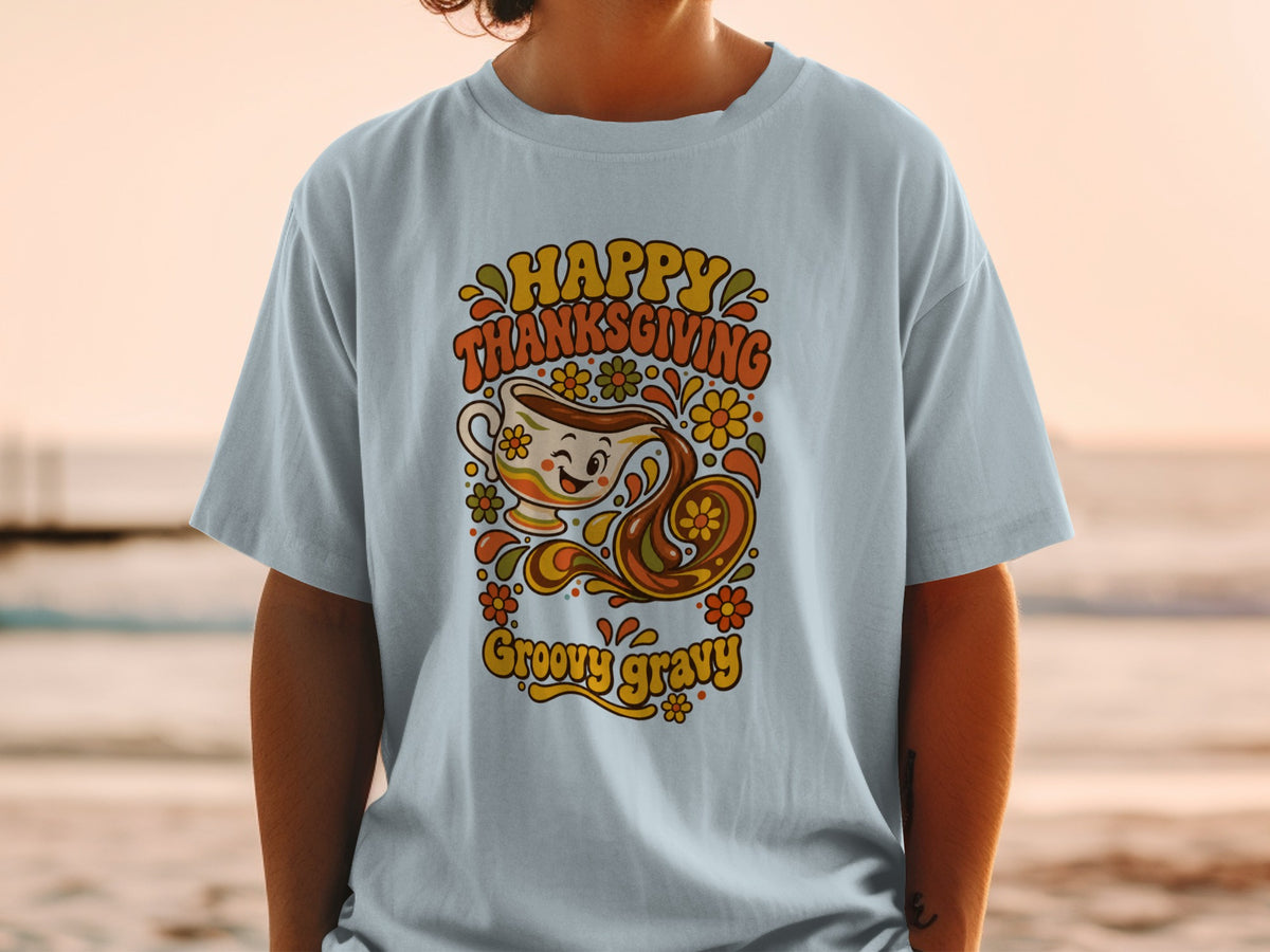Light blue t-shirt with "Happy Thanksgiving Groovy Gravy" text and retro gravy boat graphic.