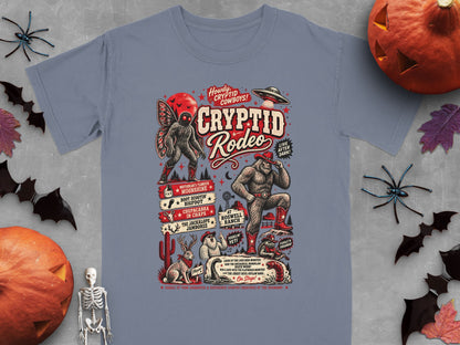 Cryptid Rodeo graphic on a gray t-shirt with cryptids, UFO, and western elements.