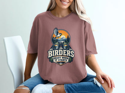 T-shirt with graphic of binoculars, bird, mountains, and text "Birders Ready When It Starts".