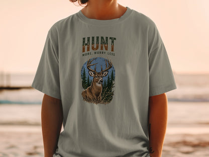 T-shirt graphic with deer, trees, and text "HUNT MORE, WORRY LESS".