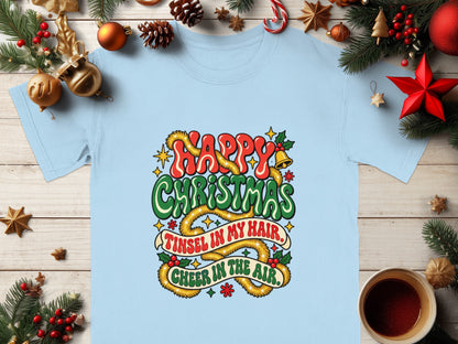 Light blue t-shirt with "Happy Christmas" and "Tinsel in my hair, cheer in the air" text.