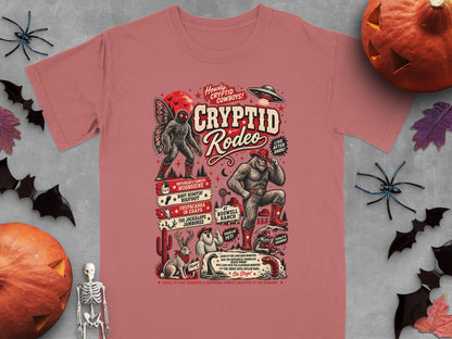 Cryptid Rodeo graphic t-shirt featuring Bigfoot, mothman, UFO, and other creatures with text.
