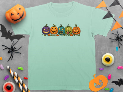 Mint t-shirt featuring a row of five cartoon Halloween pumpkins with various facial expressions.