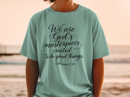 Teal t-shirt with black text "We are God's masterpiece, created... to do good things. -Ephesians 2:10".