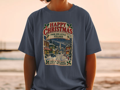 T-shirt graphic with "Happy Christmas From Our Little Village" and a snowy village scene.