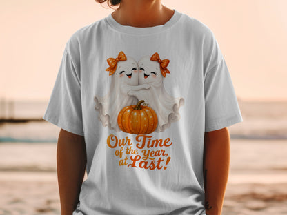 Two cute ghosts hug a pumpkin with text "Our Time of the Year, at Last!".