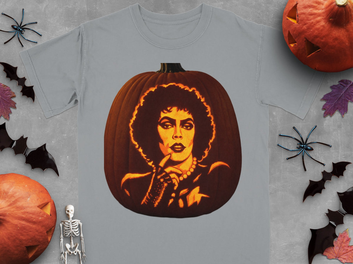 A gray t-shirt featuring a glowing carved pumpkin depicting a person with dark curly hair and heavy makeup.