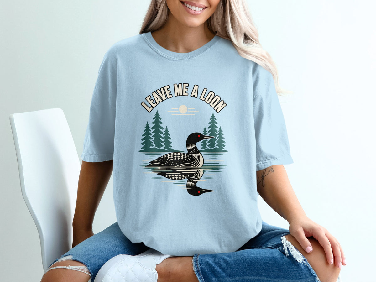 Light blue t-shirt with "Leave Me A Loon" graphic featuring a loon on water and trees.