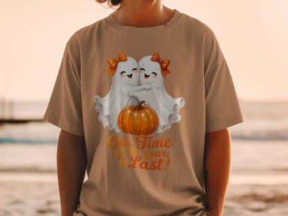 Two ghosts hugging a pumpkin with text "Our Time of the year, at Last!"