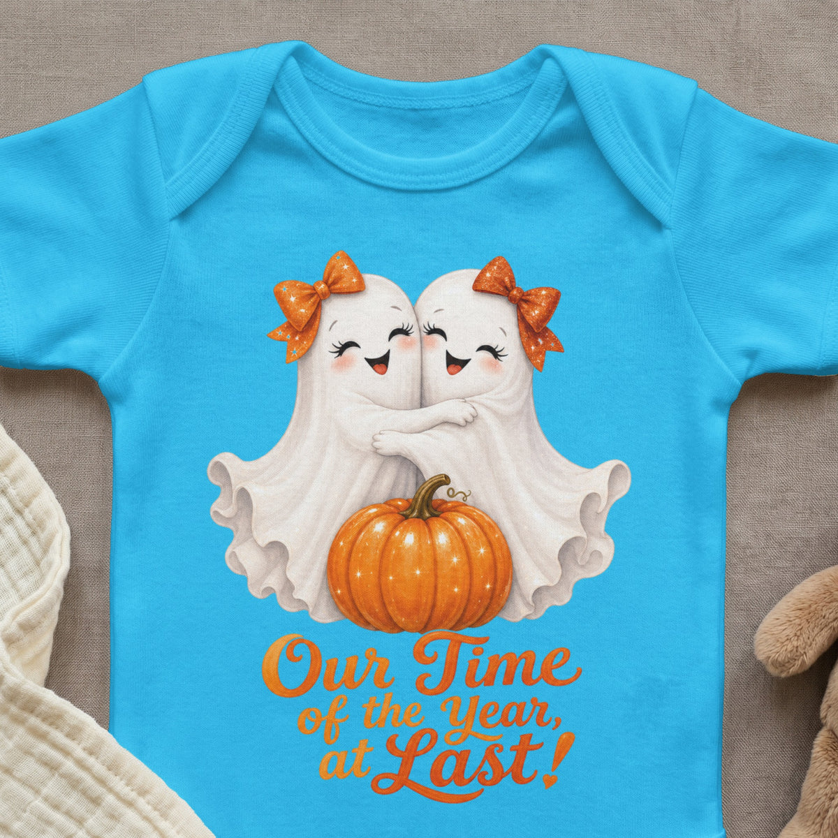 Blue baby bodysuit with two ghosts hugging, pumpkin, and "Our Time of the Year, at Last!" text.