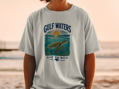 Light gray t-shirt with a graphic of a sea turtle and sunset, "GULF WATERS KEEP 'EM WILD" text.