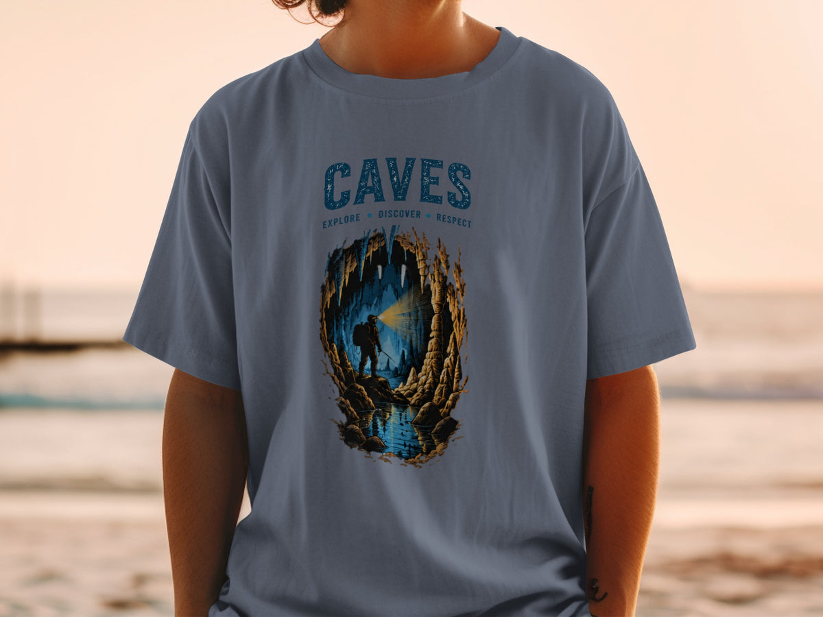 T-shirt featuring the word "CAVES" above a caver exploring a cave with a flashlight.