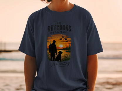 T-shirt with silhouette of hunter and dog at sunset, "The Outdoors Isn't a Place..." text.