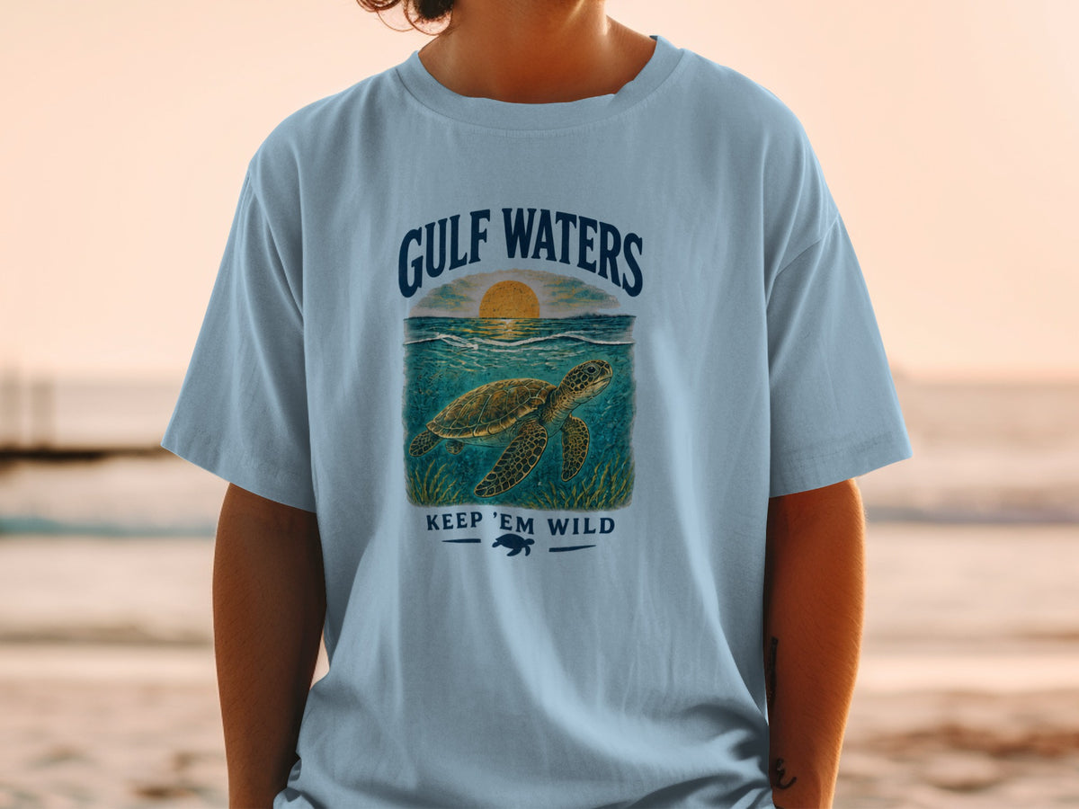 Light blue t-shirt with "Gulf Waters" text, a sea turtle, and "Keep 'Em Wild" message.