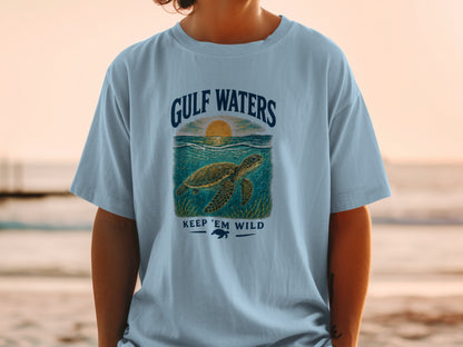 Light blue t-shirt with "Gulf Waters" text, a sea turtle, and "Keep 'Em Wild" message.