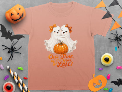 Peach t-shirt with two ghosts hugging a pumpkin and text "Our Time of the Year, at Last!".