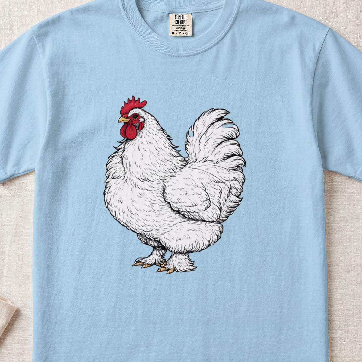 Light blue t-shirt featuring a detailed illustration of a white rooster centered on the chest.