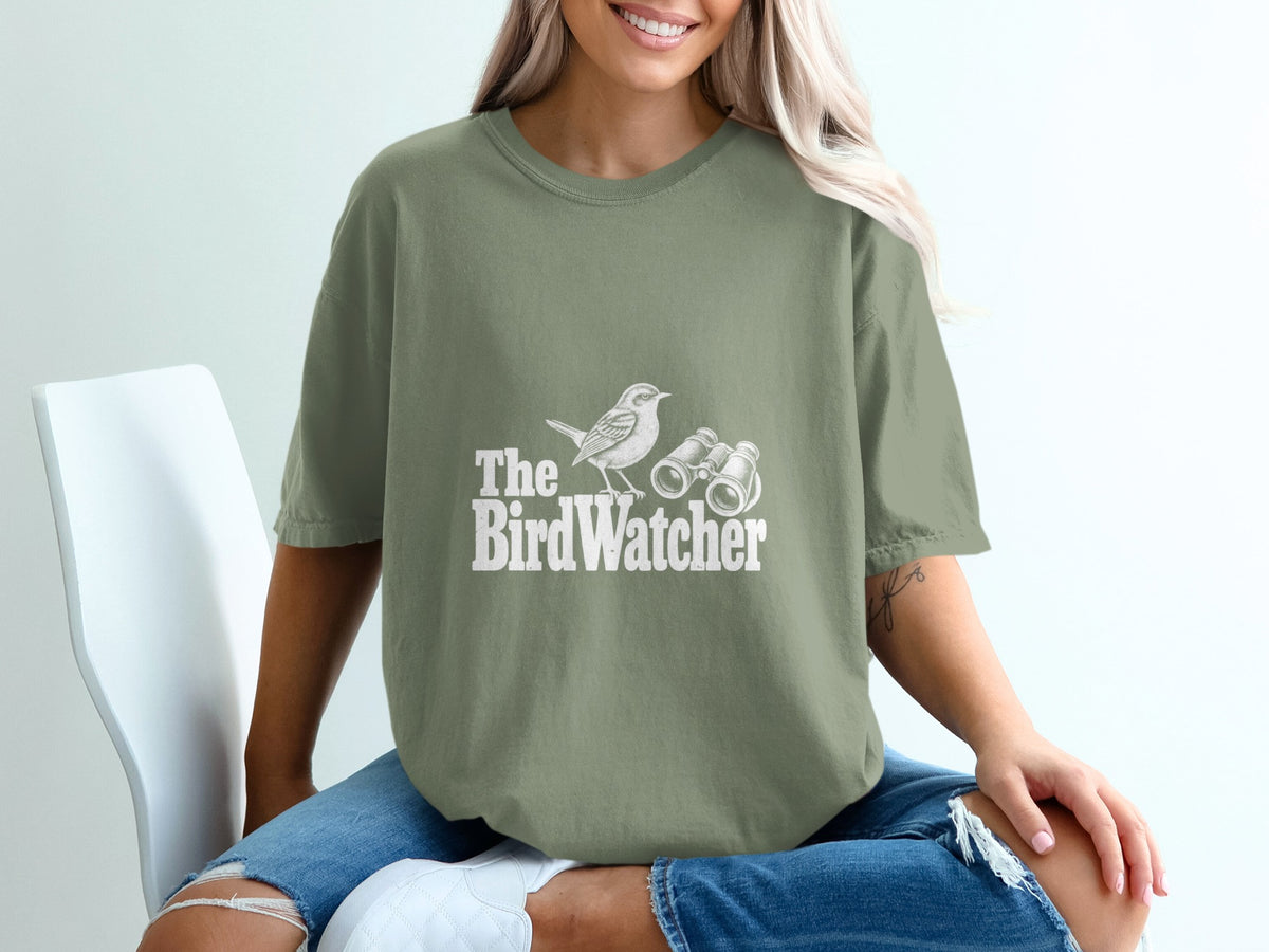 Green t-shirt with white text and graphic of a bird and binoculars reading "The BirdWatcher".