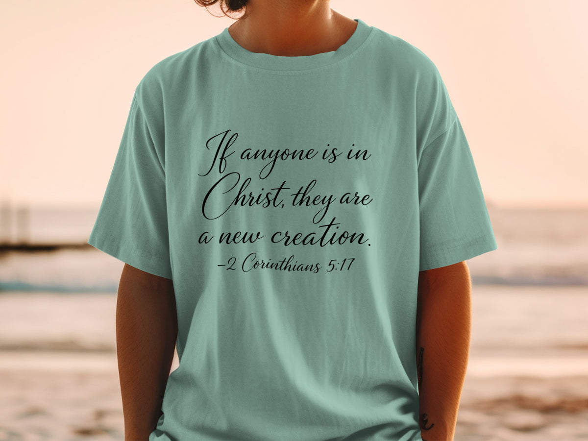 Teal t-shirt with text "If anyone is in Christ, they are a new creation. -2 Corinthians 5:17".