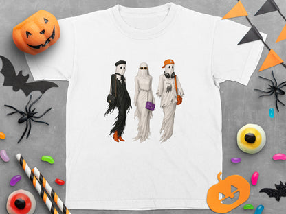 White t-shirt featuring three fashionable ghosts with accessories, set against a Halloween-themed backdrop.