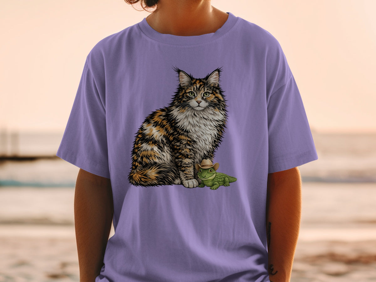 A person wearing a pastel purple t-shirt featuring an illustration of a fluffy calico cat next to a small green alligator wearing a cowboy hat.