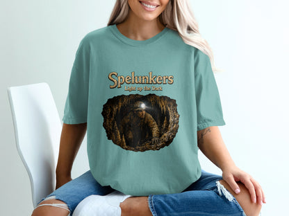 Teal t-shirt with "Spelunkers Light up the Dark" text and cave explorer graphic.