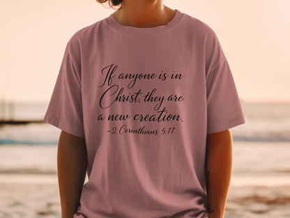 Mauve t-shirt with "If anyone is in Christ, they are a new creation. -2 Corinthians 5:17"