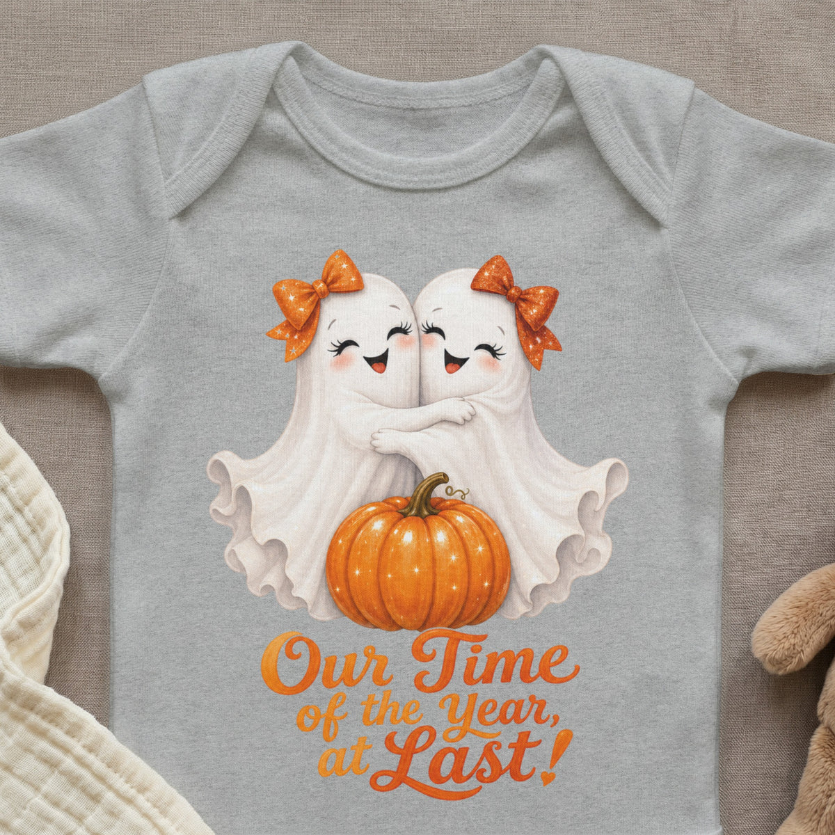 Two ghosts hug over a pumpkin with text "Our Time of the Year, at Last!".