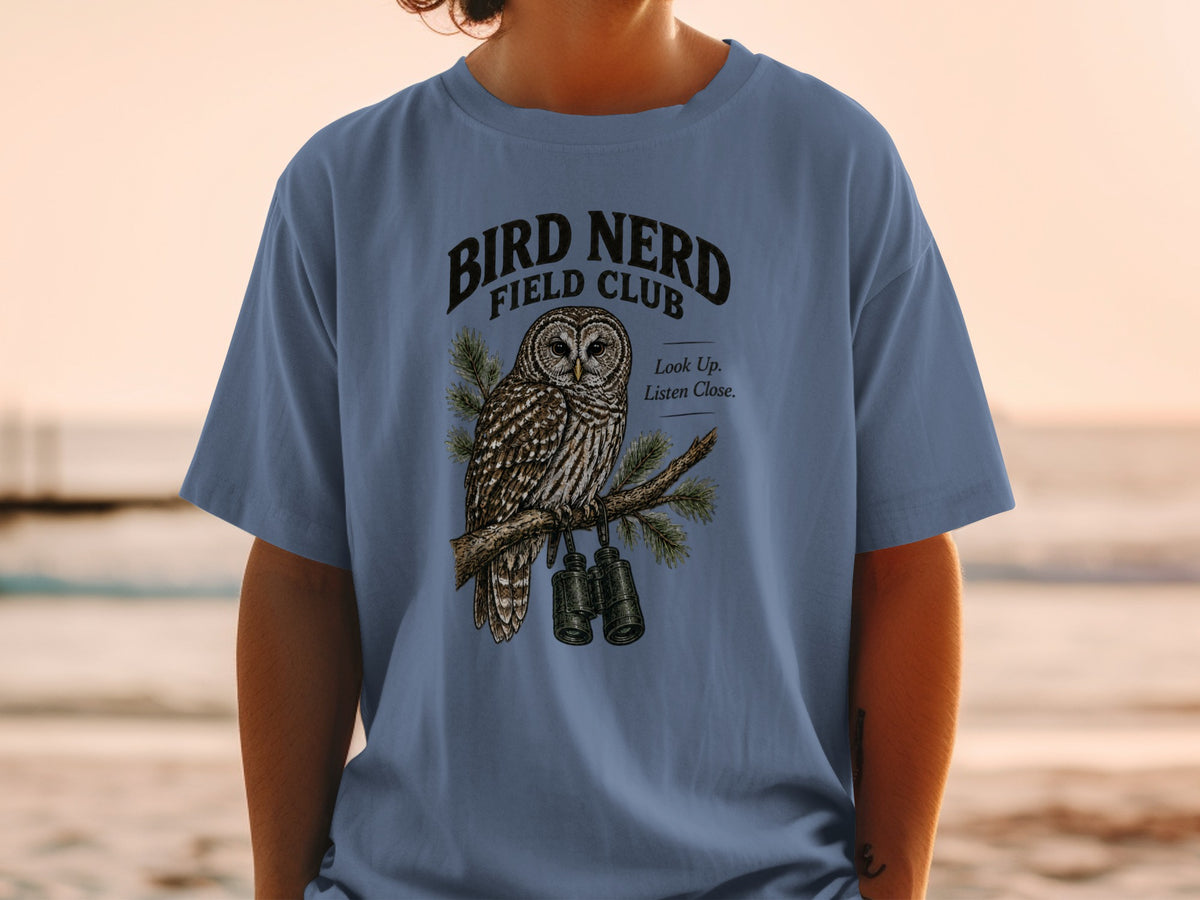 Blue t-shirt with "Bird Nerd Field Club" text and an owl holding binoculars.