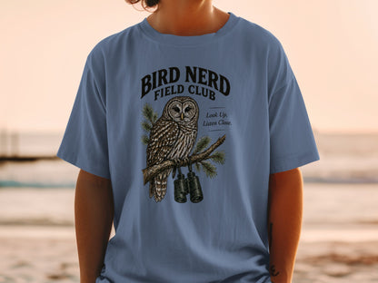 Blue t-shirt with "Bird Nerd Field Club" text and an owl holding binoculars.