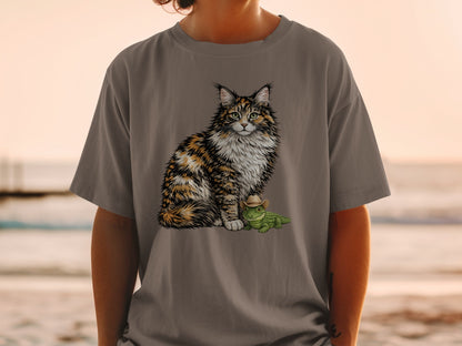 Fluffy cat with cowboy hat wearing green lizard on gray t-shirt.