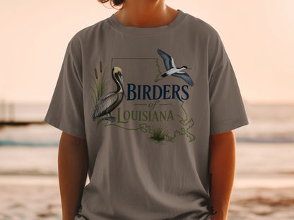 Brown pelican and flying bird on a t-shirt with "Birders of Louisiana" text.
