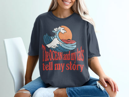 T-shirt with ocean wave graphic and text "The OCEAN and my tats tell my story".