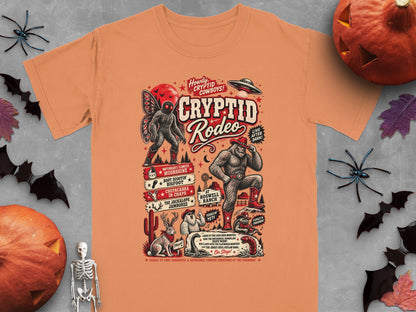Orange t-shirt graphic: Cryptid Rodeo with Mothman, Bigfoot, Yeti, and other creatures.