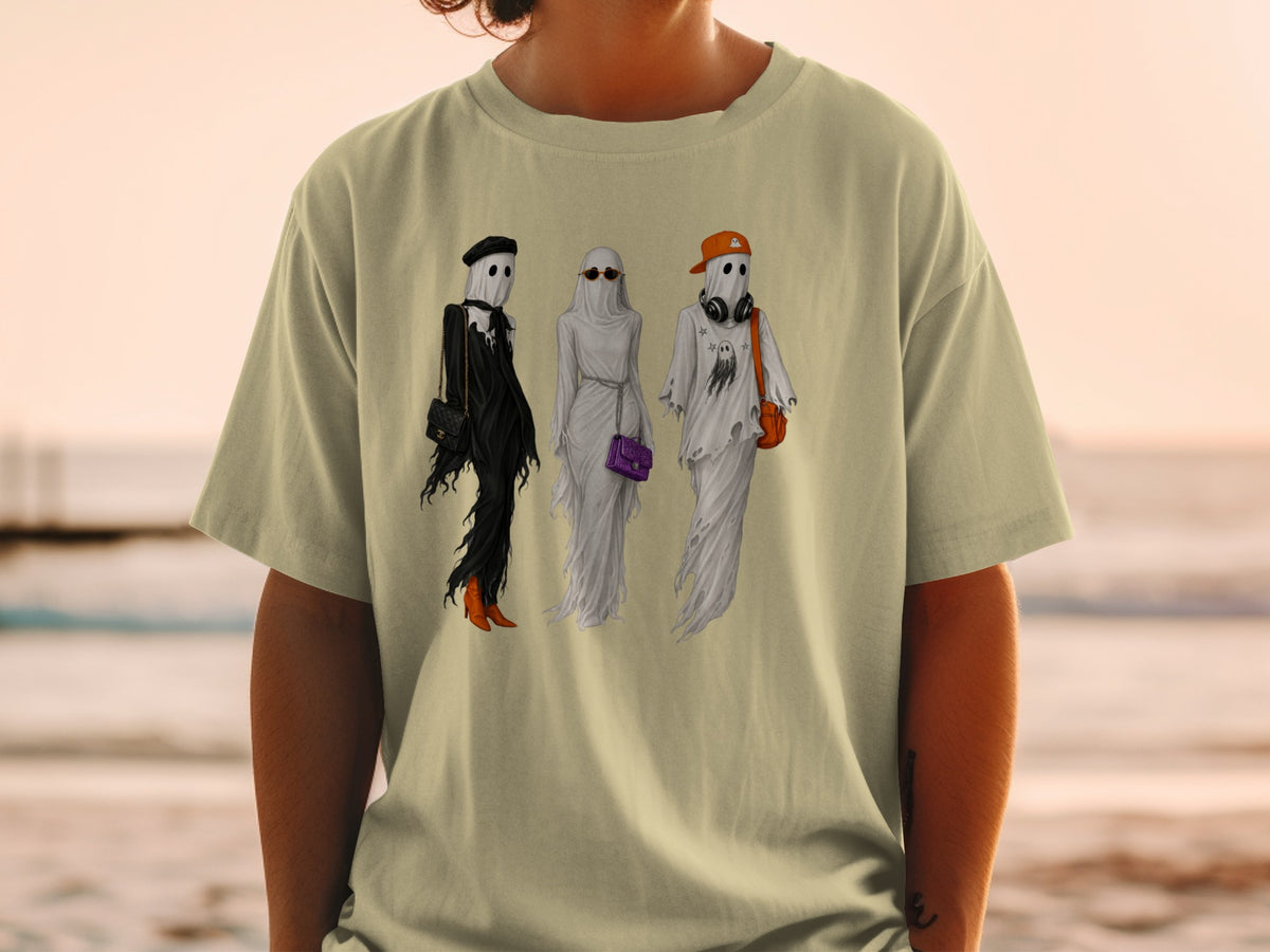 Three fashionable ghosts with accessories on a tan t-shirt.