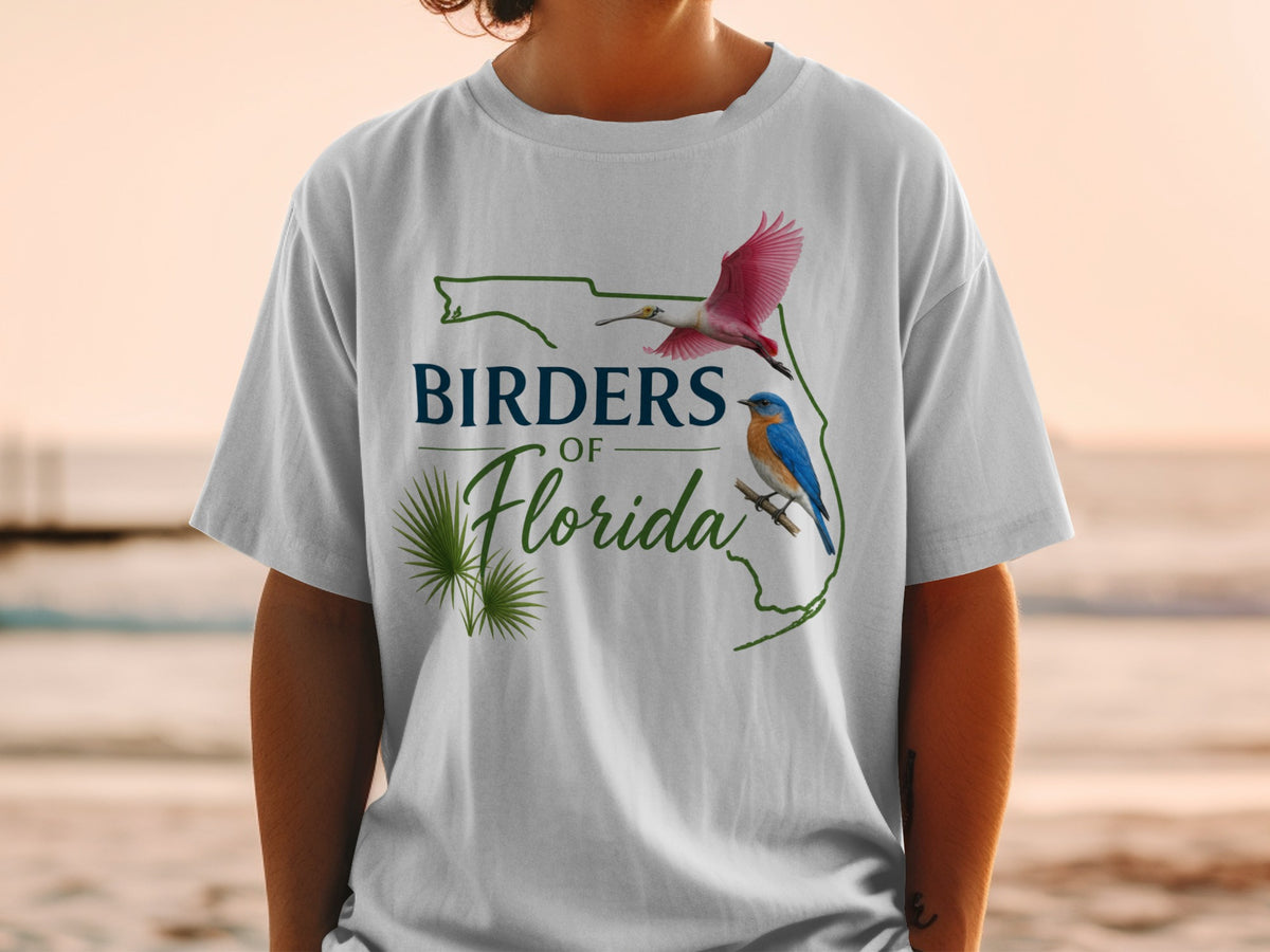 White t-shirt graphic with "Birders of Florida" text, palm fronds, and two birds.