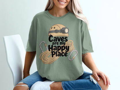 Green t-shirt with graphic of helmet, rope, and carabiners, text says "Caves are my Happy Place".