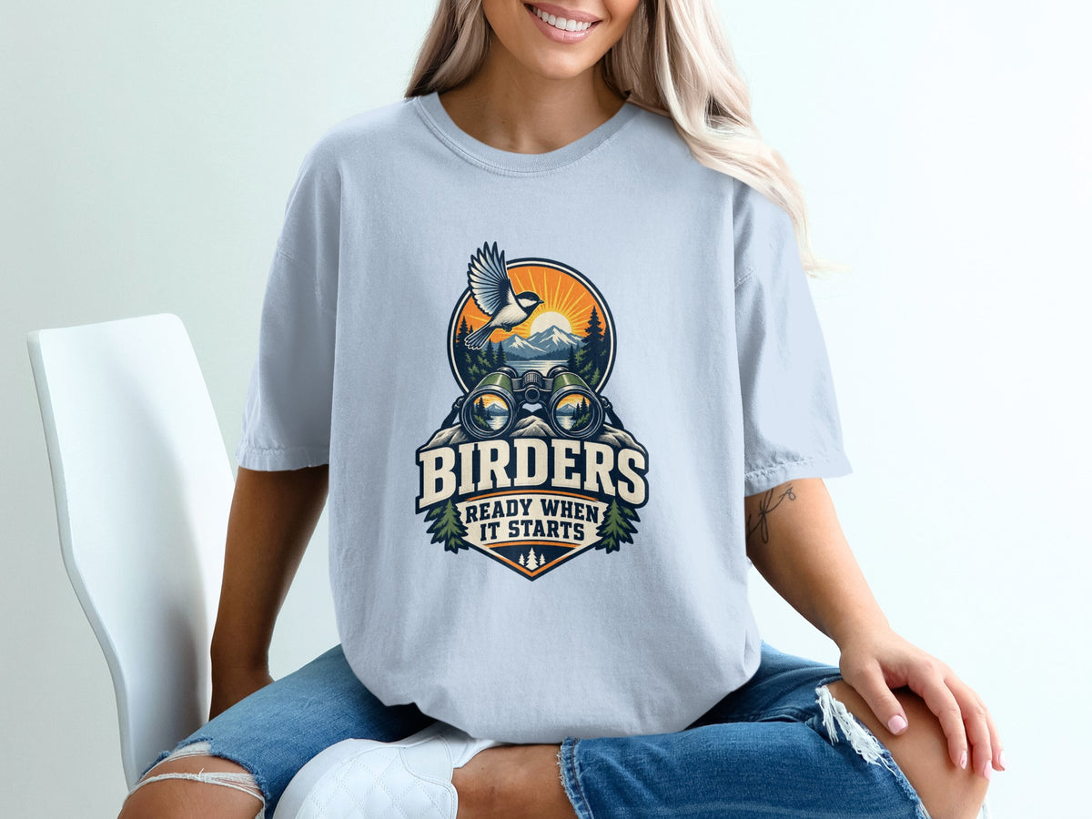 T-shirt graphic with binoculars, bird, mountains, and text "BIRDERS READY WHEN IT STARTS".