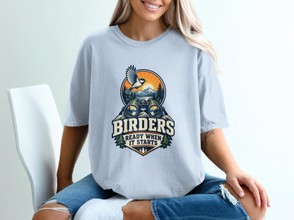 T-shirt graphic with binoculars, bird, mountains, and text "BIRDERS READY WHEN IT STARTS".