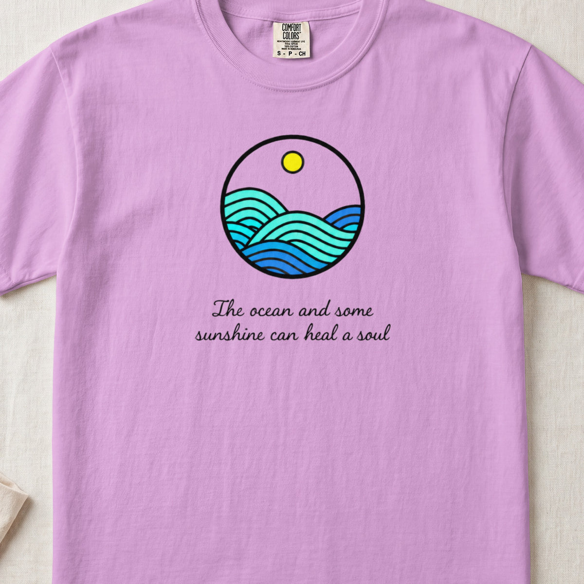 Light purple t-shirt featuring a circular ocean graphic and the text The ocean and some sunshine can heal a soul.