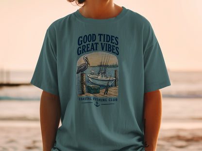 T-shirt graphic with pelican, boat, and text "Good Tides Great Vibes".